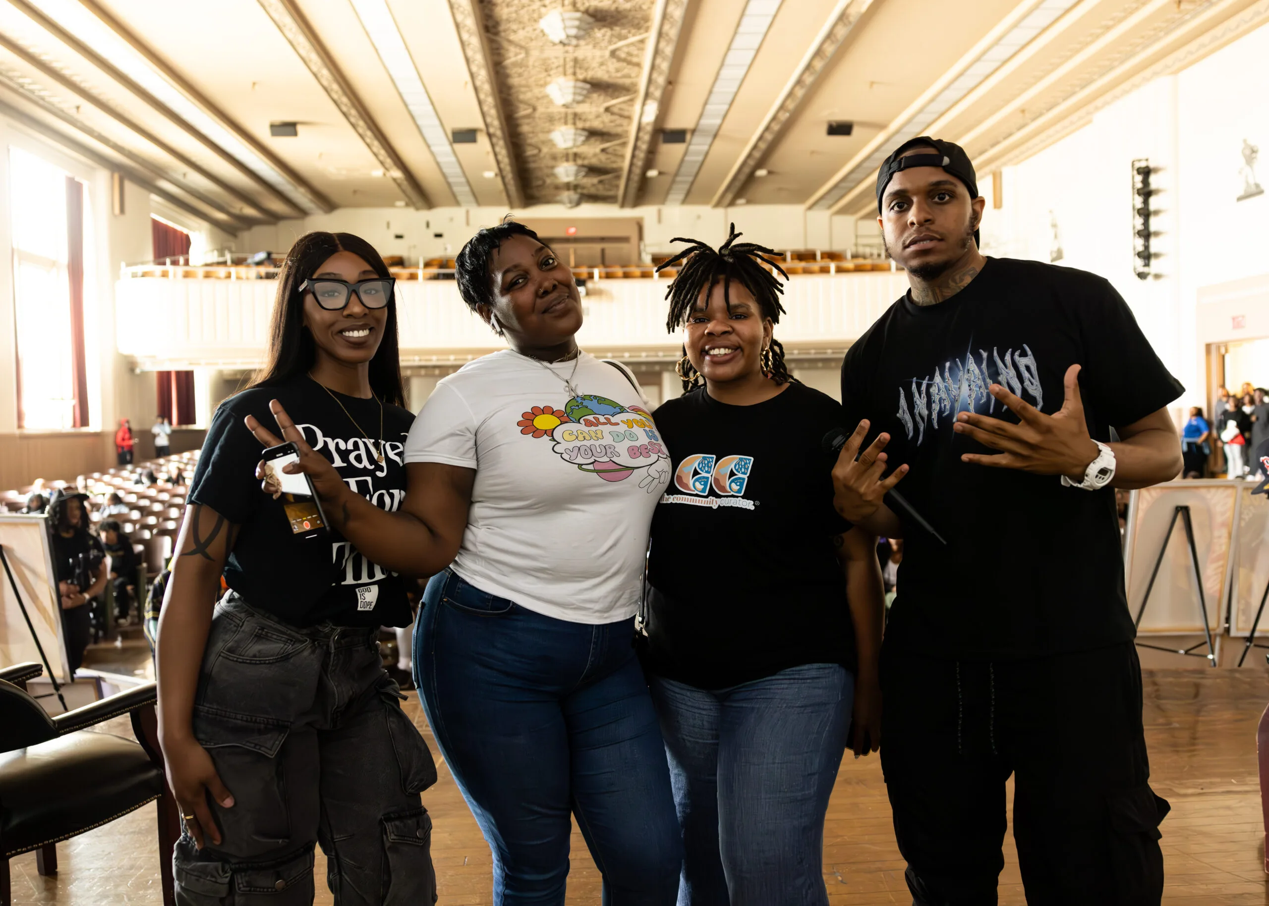 Four organizers of the conflict resolution tour post for a photo. They all appear to be Black; three appear to be women; Manny is pictured on the far right of the group.