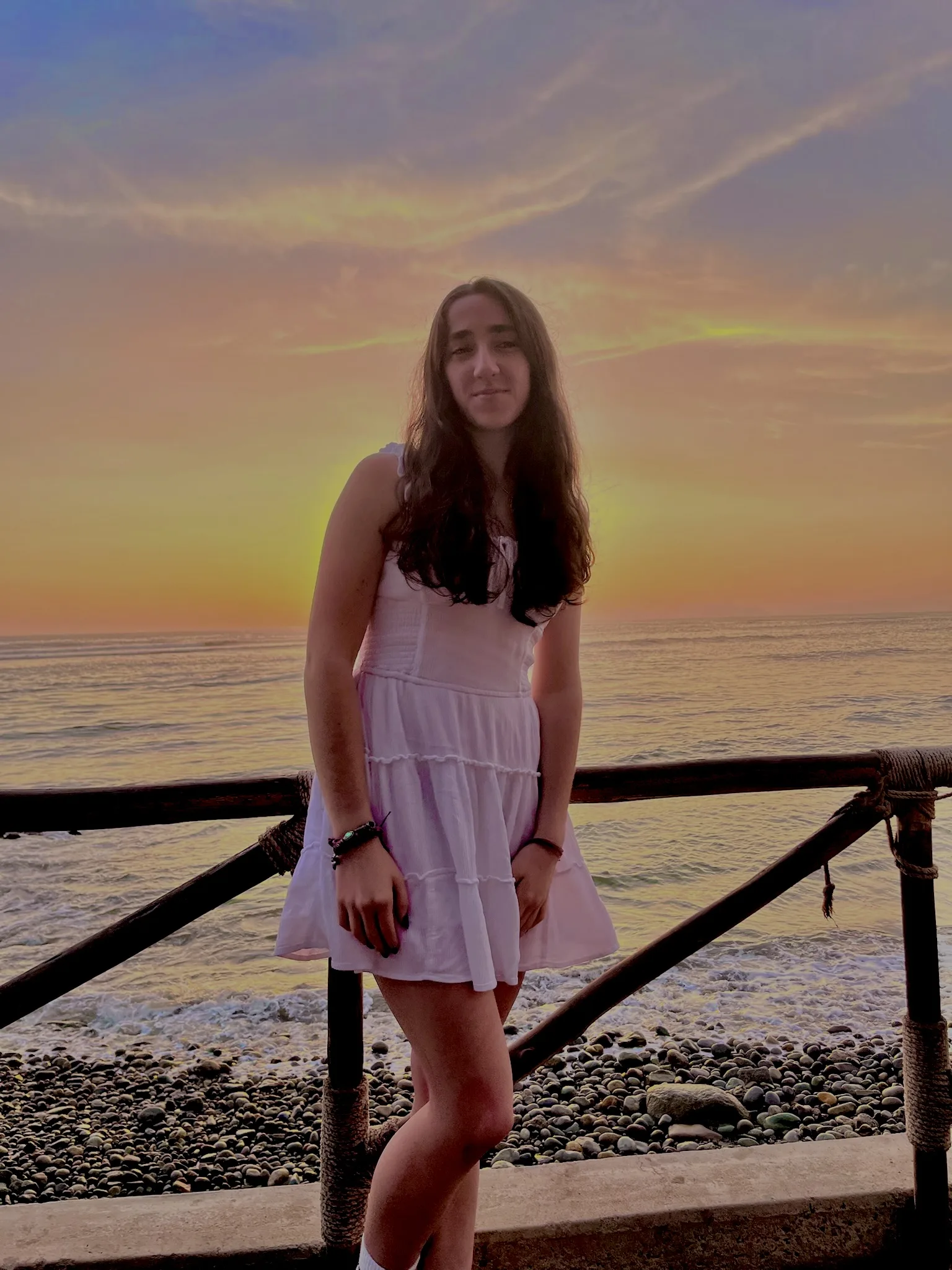 Gabi Iler, a Students Demand Action Text Team Captain, poses for a photo at sunset along a waterfront.