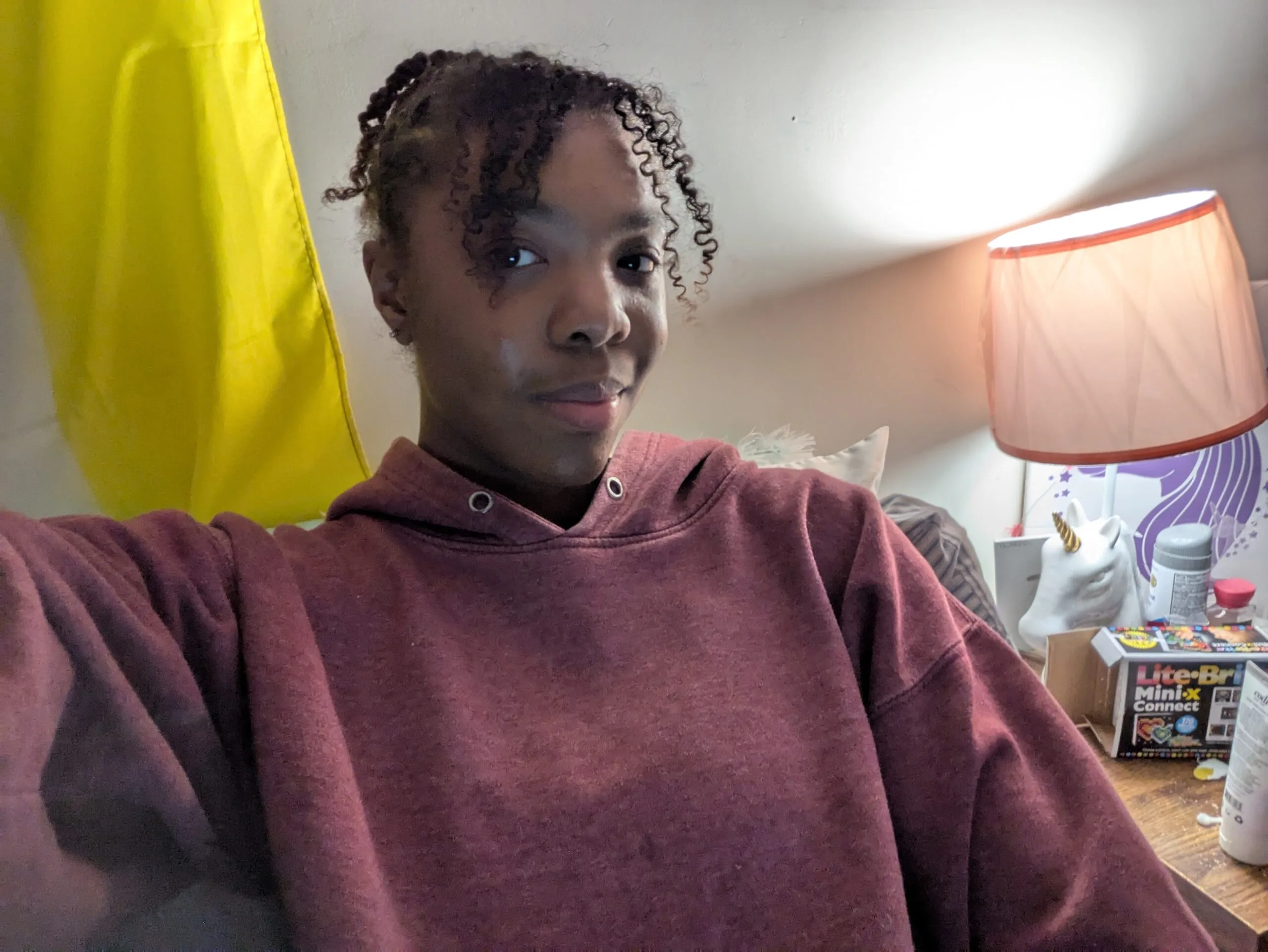 Jordyn Parker, a Students Demand Action Text Team Captain, takes a selfie while wearing a maroon hooded sweatshirt.