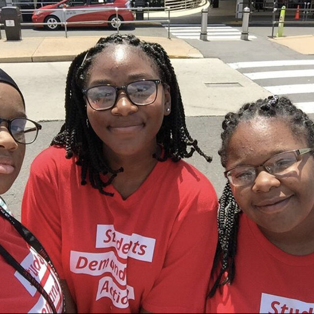 LaTayla and two other Students Demand Action volunteers smile and take a selfie while wearing their Students Demand Action t-shirts.