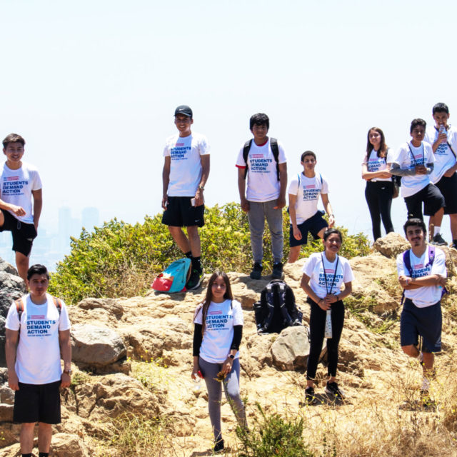 A group 17 participants in the Summer Leadership Academy wear Students Demand Action shirts while on a hike in California