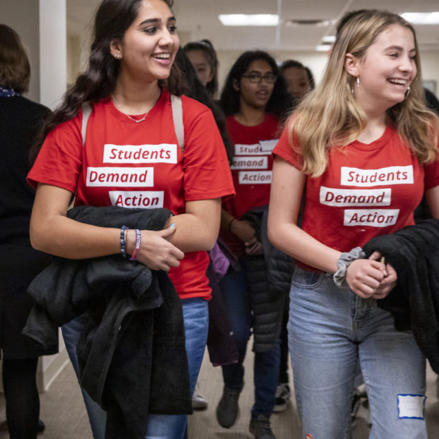 A group of more than five Students Demand Action volunteers walk through an office hallway on Advocacy Day in Richmond.