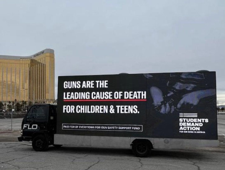 Truck displaying the message “Guns are the leading cause of death for children & teens.”