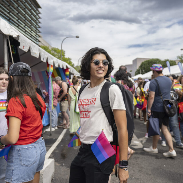 A Students Demand Action volunteer wearing sunglasses and a white Student Demand Action t-shirt.