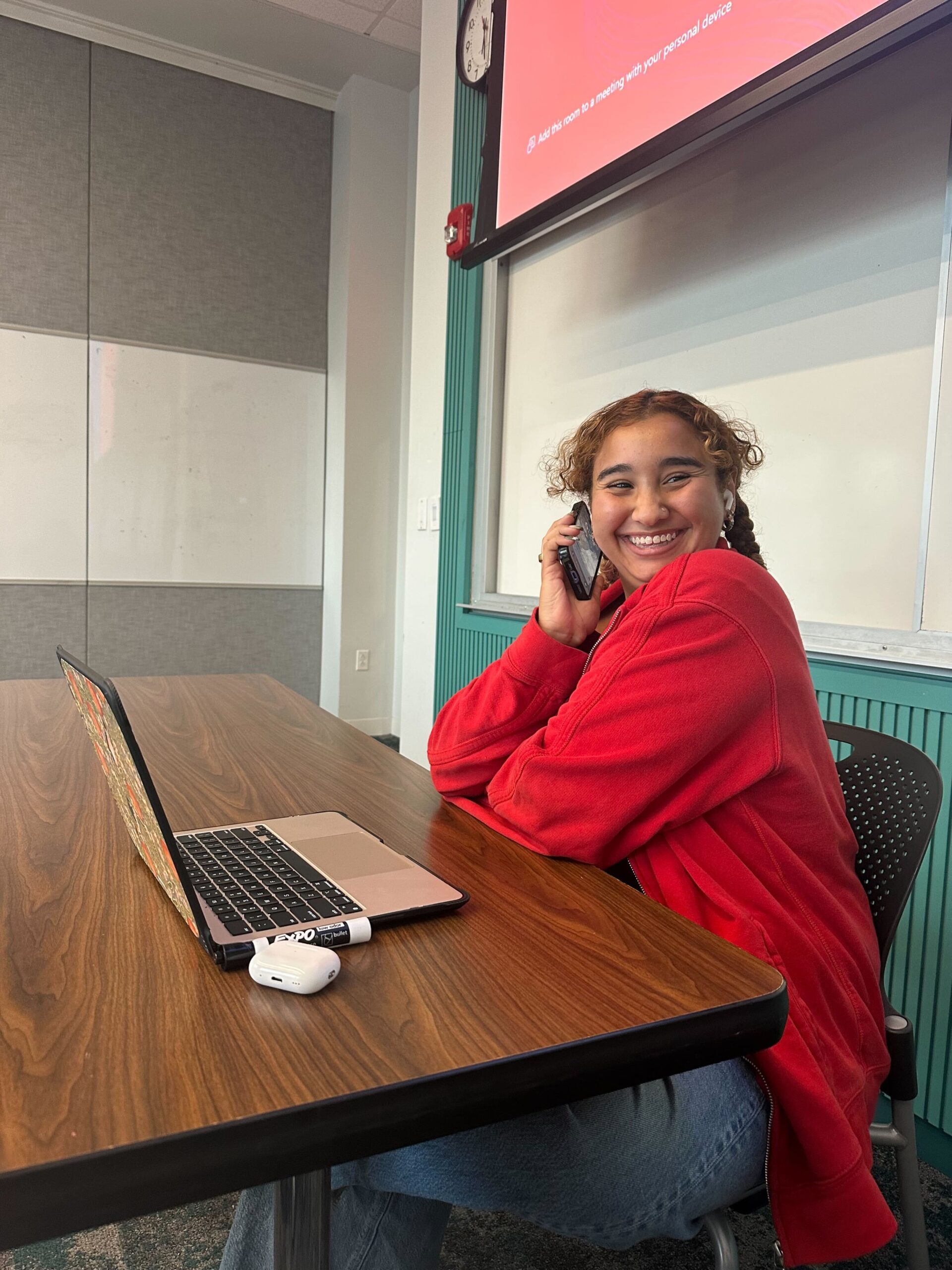 A student smiles for the camera while phone banking at Northeastern University.